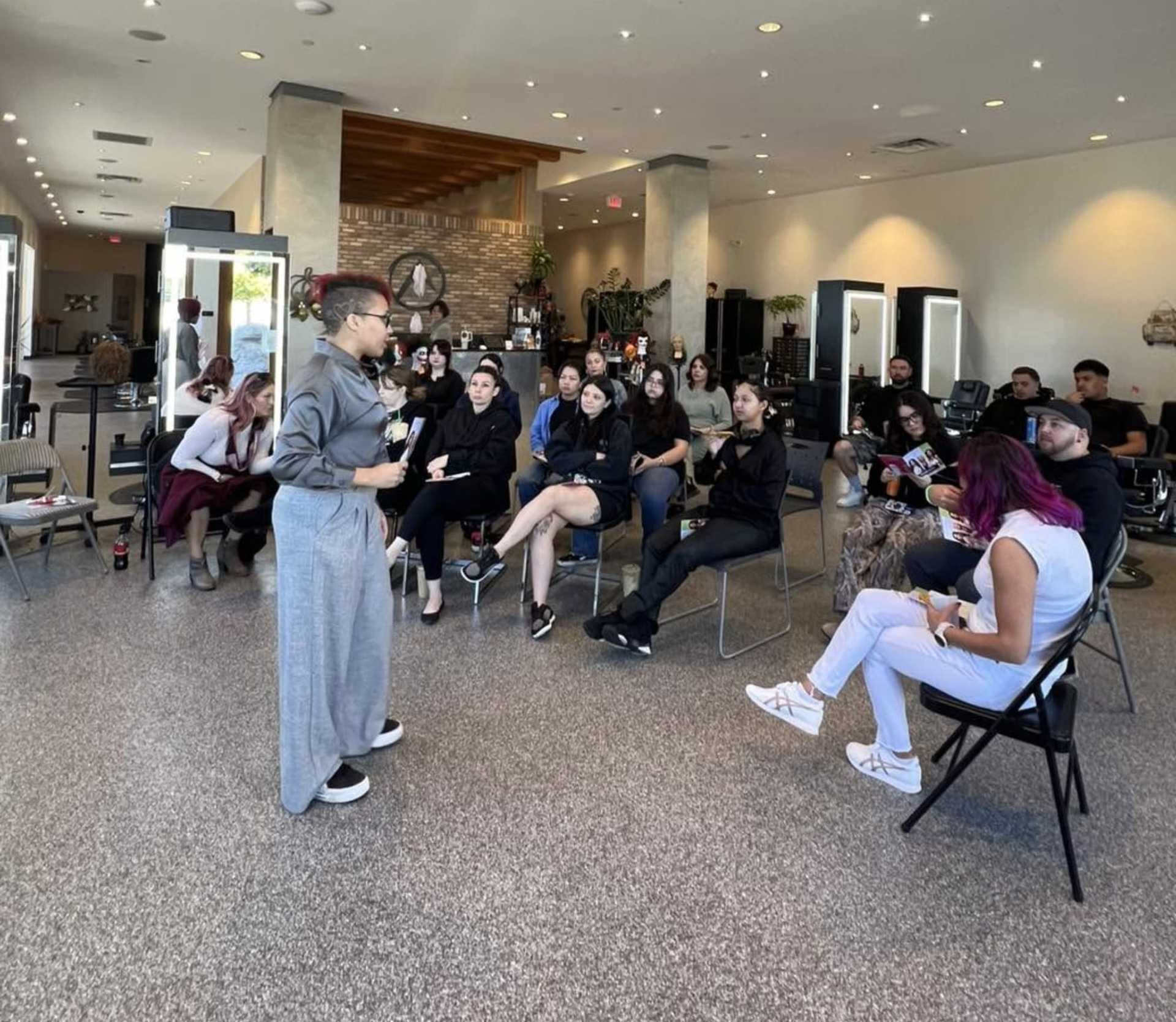 Group discussion in a bright room, with a speaker addressing seated attendees.